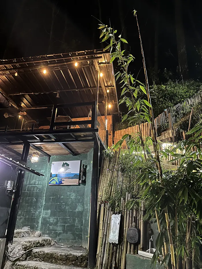 Area penerimaan tamu dengan pagar bambu dan lampu gantung