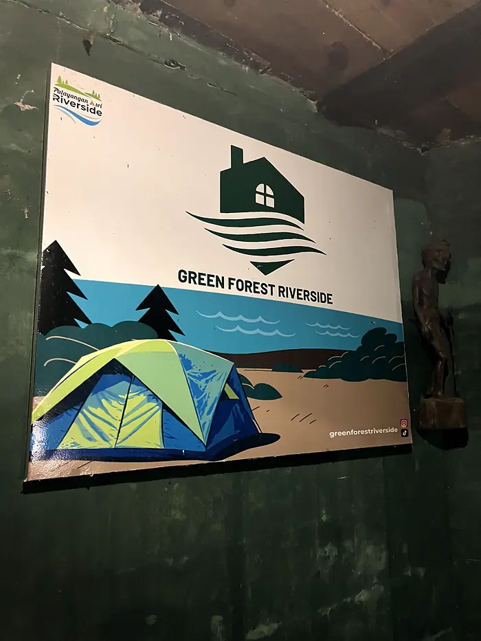 Papan nama Green Forest Riverside di area penerimaan tamu